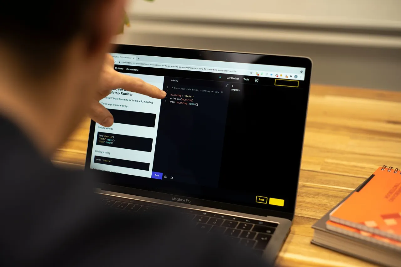 A person learning to code using a laptop