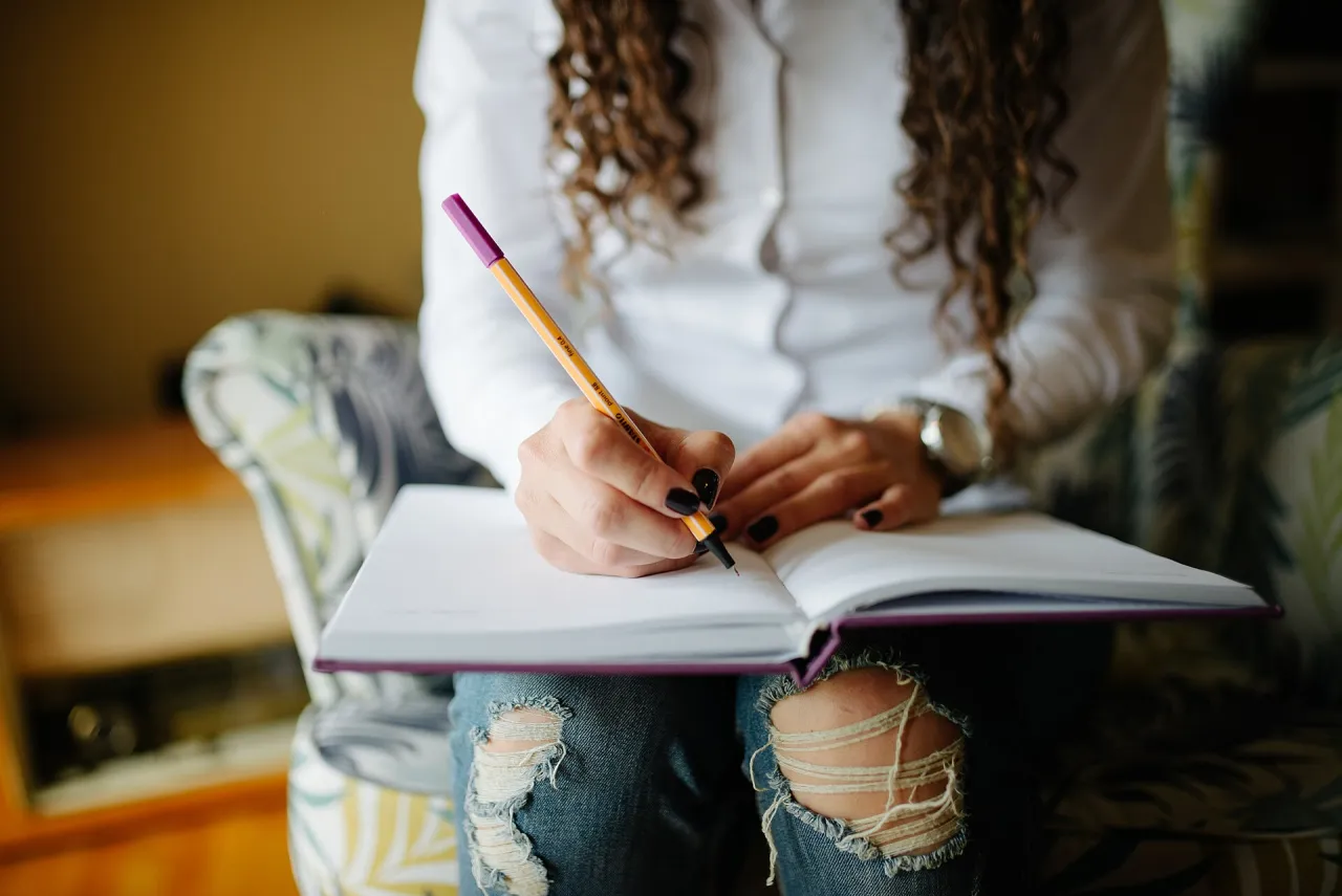 Hands writing notes in an open personal planner