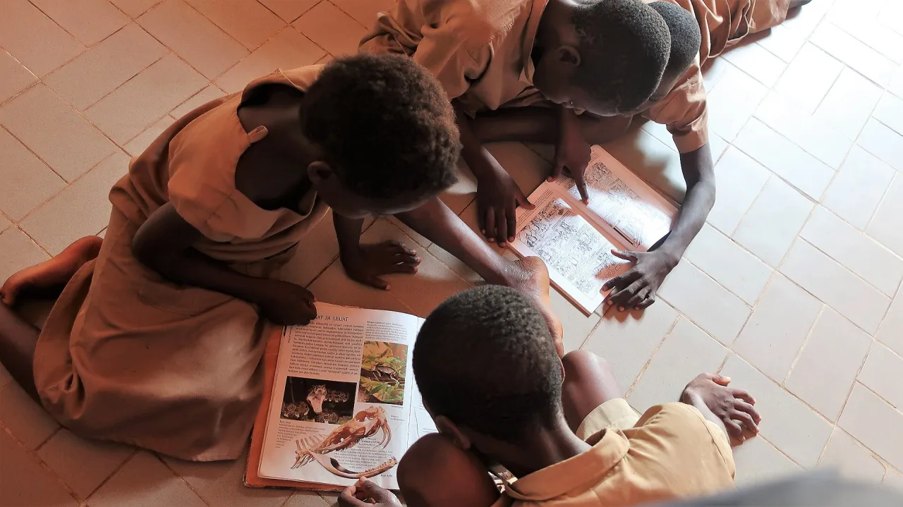 Schoolchildren reading books at Villa Karo in Benin
