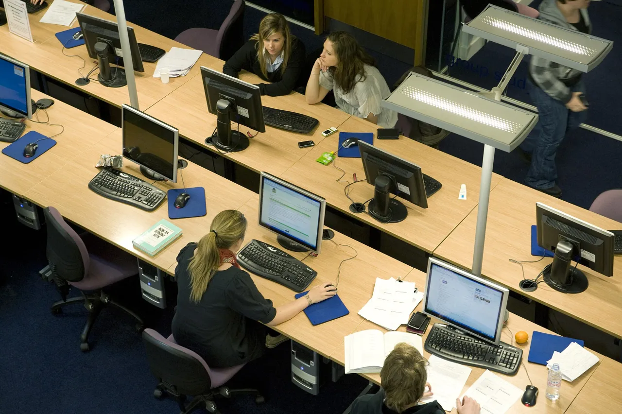 University students using computers in a library learning space