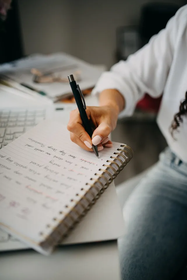 Woman writing planning notes in a notebook